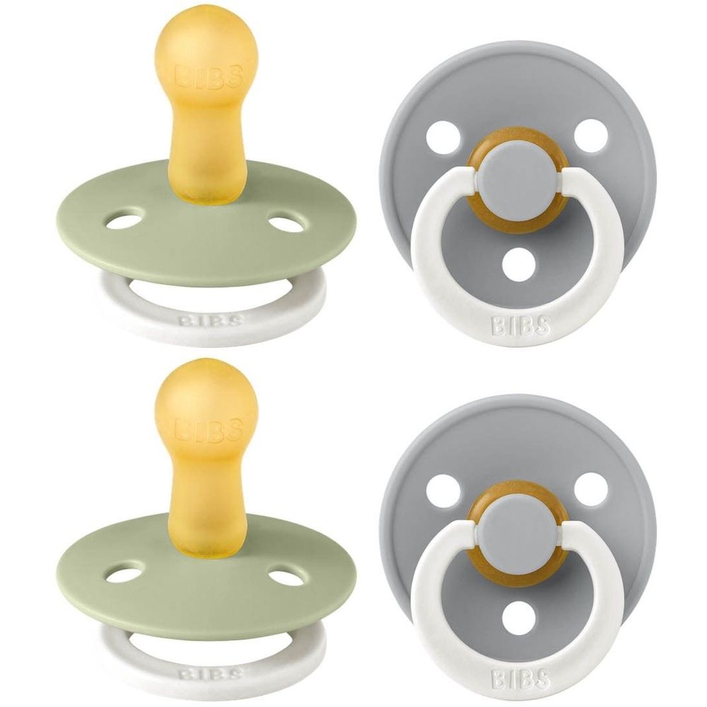 Deux sucettes. Boucliers ronds gris et verts. Tétines rondes jaunes. Anneaux blancs avec logo BIBS. Vue rapprochée.