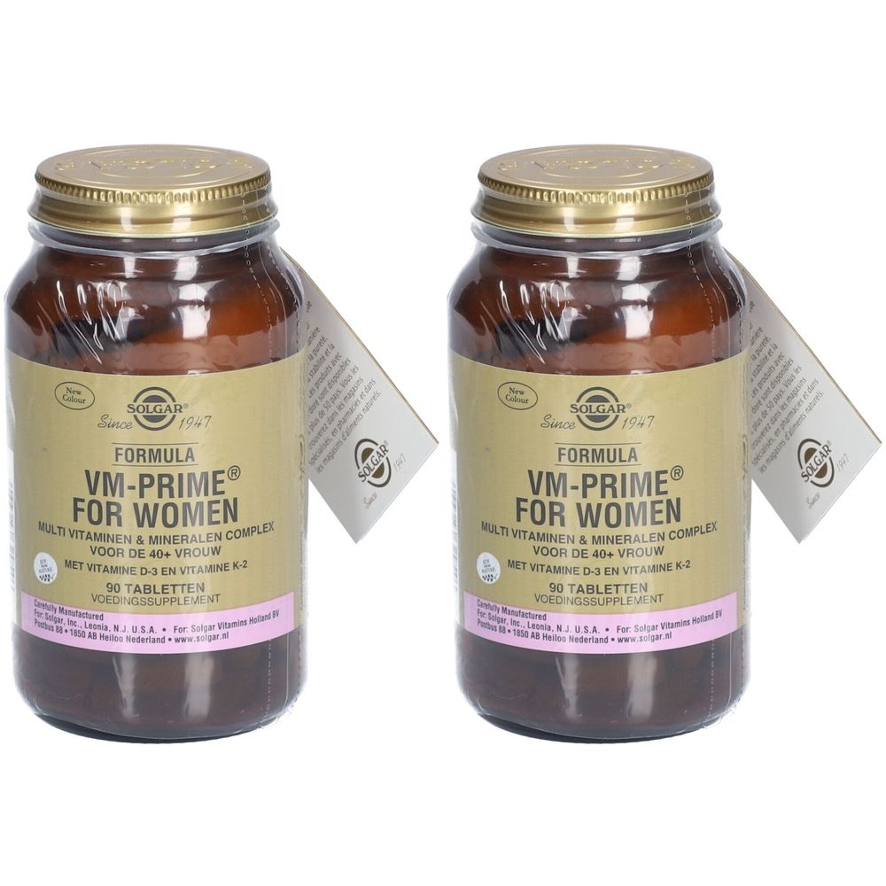 Twee bruine glazen flessen met gouden doppen. De etiketten tonen "VM-PRIME FOR WOMEN". Er zijn labels met logo en tekst bijgevoegd.