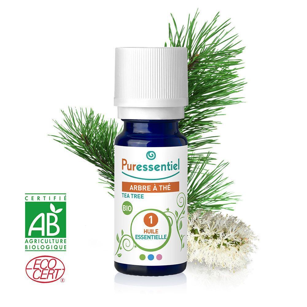 Donkerblauwe glazen fles met witte dop, met tea tree olie. Met biologische keurmerken en dennentakken.