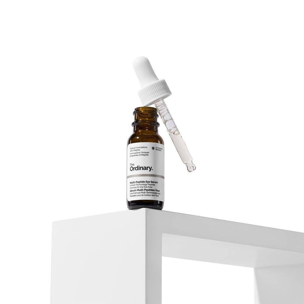 Een fles The Ordinary Multi-Peptide Eye Serum met pipet, op een wit plateau.