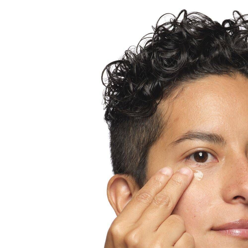 Een persoon brengt The Ordinary Multi-Peptide Eye Serum aan op de oogzone.