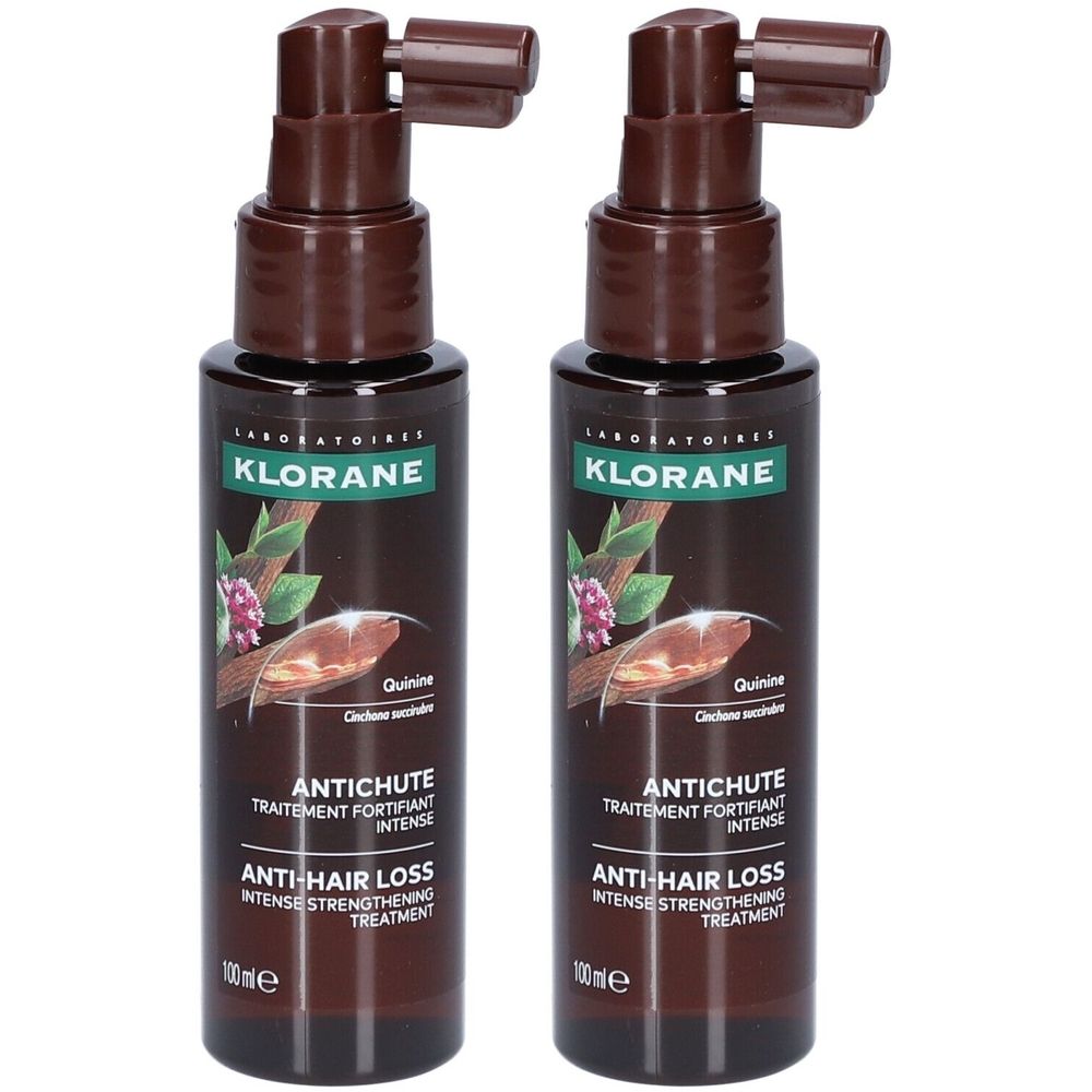 Twee bruine flessen met sproeikop. Opschrift: Klorane, Antichute, Anti-haaruitval. Flessen met bruine vloeistof.