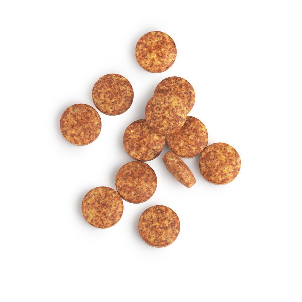 Meerdere ronde, gevlekte multivitamine tabletten op een witte achtergrond.