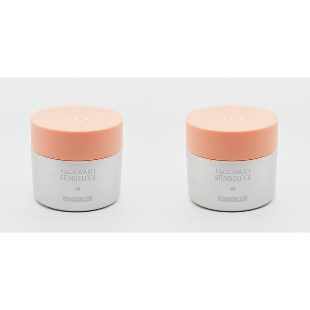Twee cilindrische potten met roze deksels. Op de voorkant staat "FACE WASH SENSITIVE".