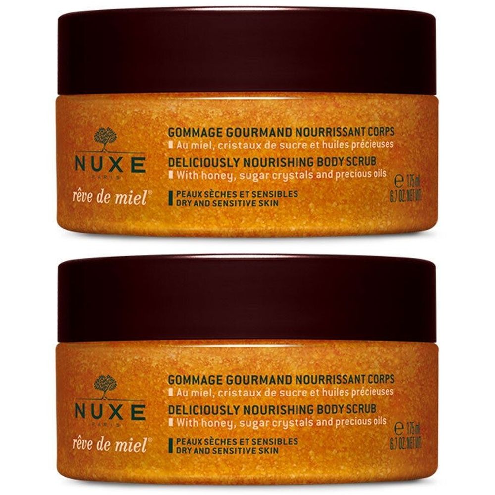 Twee potten lichaamsscrub. Bruin deksel, goudkleurige inhoud. Opschrift: Nuxe, Rêve de Miel, Gommage Gourmand Nourrissant Corps.