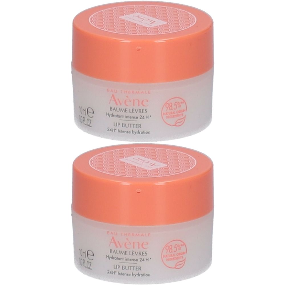 Twee potjes lippenbalsem. Witte, transparante potjes met oranje deksels. Opschrift: Avène, Baume Lèvres, Lip Butter.