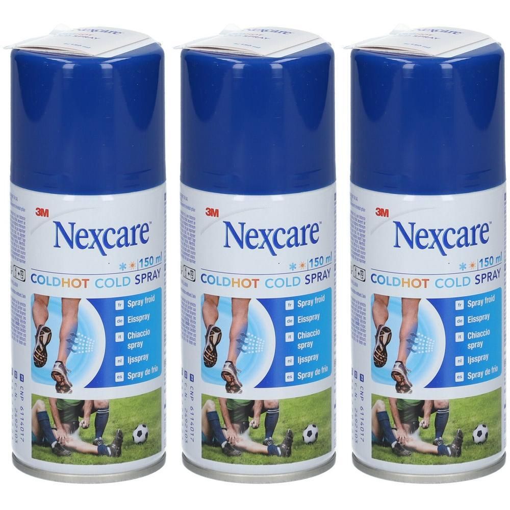 Drie spuitbussen Nexcare Coldhot spray. Blauwe doppen, witte etiketten met productnaam en afbeeldingen. Op gras geplaatst.