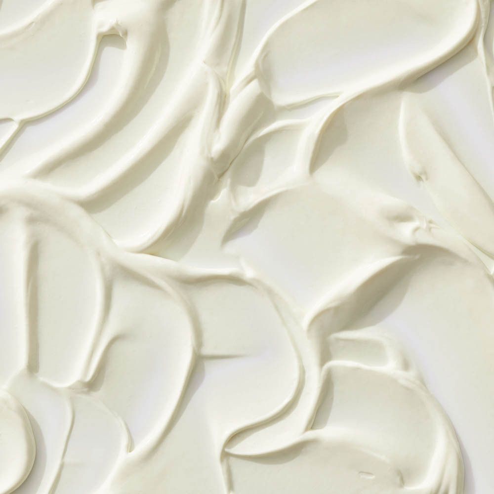 Close-up van witte crème met golvende texturen.