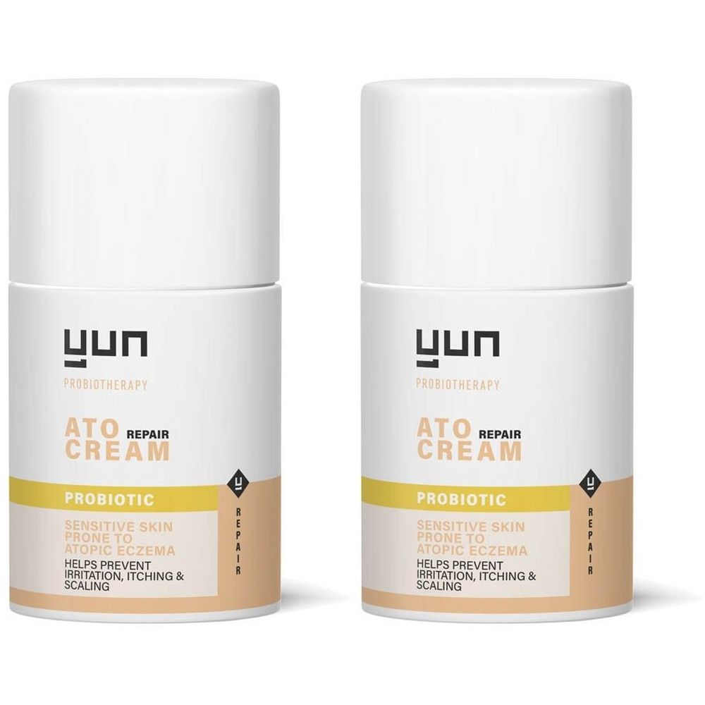 Twee witte crèmetubes met "YUN" logo. Opschrift: ATO REPAIR CREAM, PROBIOTIC, voor gevoelige huid met atopisch eczeem.