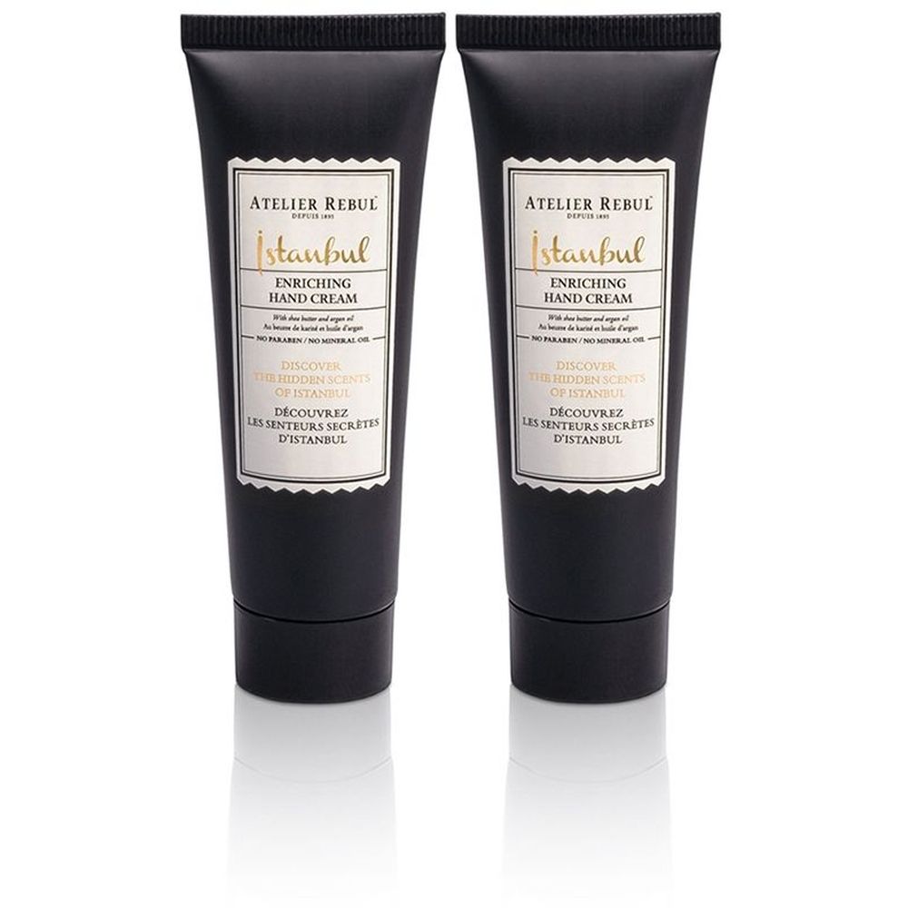 Twee zwarte handcrèmetubes. Op elke tube staat "ATELIER REBUL Istanbul ENRICHING HAND CREAM". 