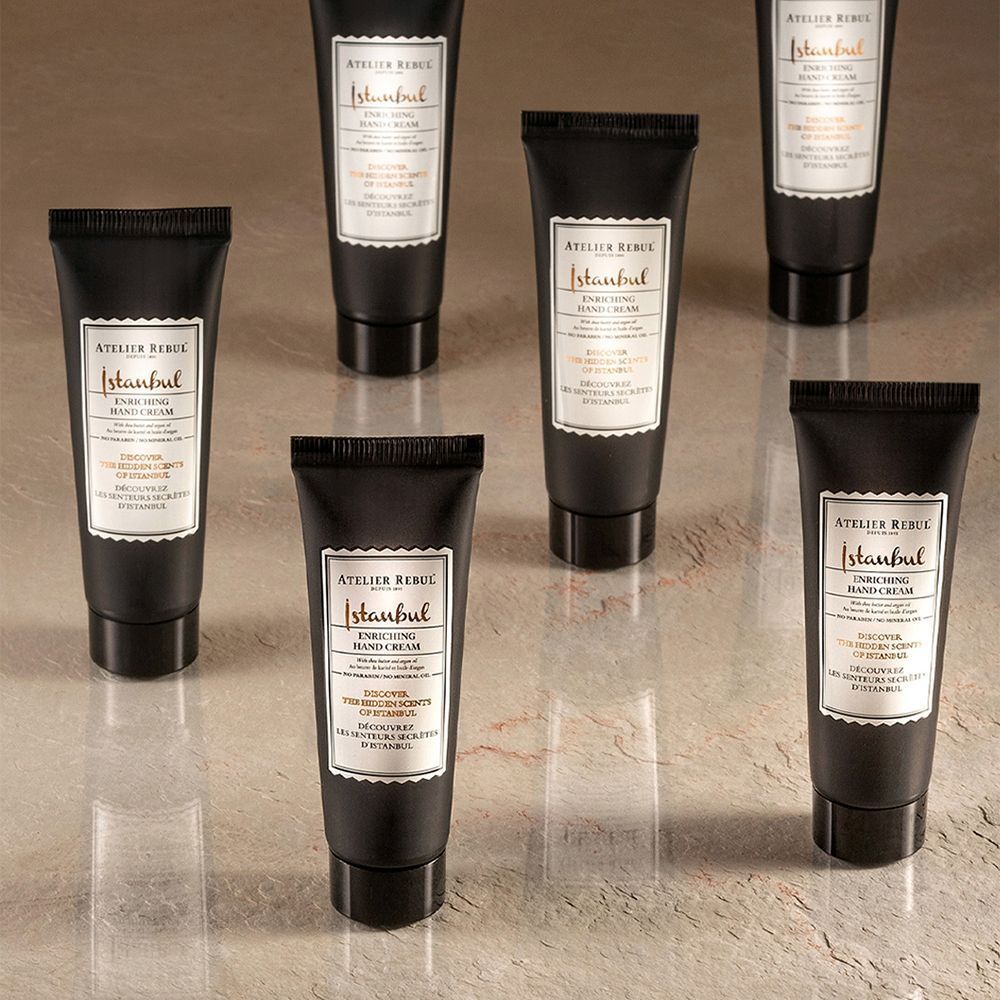 Zeven zwarte tubes handcrème. Opschrift: ATELIER REBUL Istanbul Enriching Hand Cream.