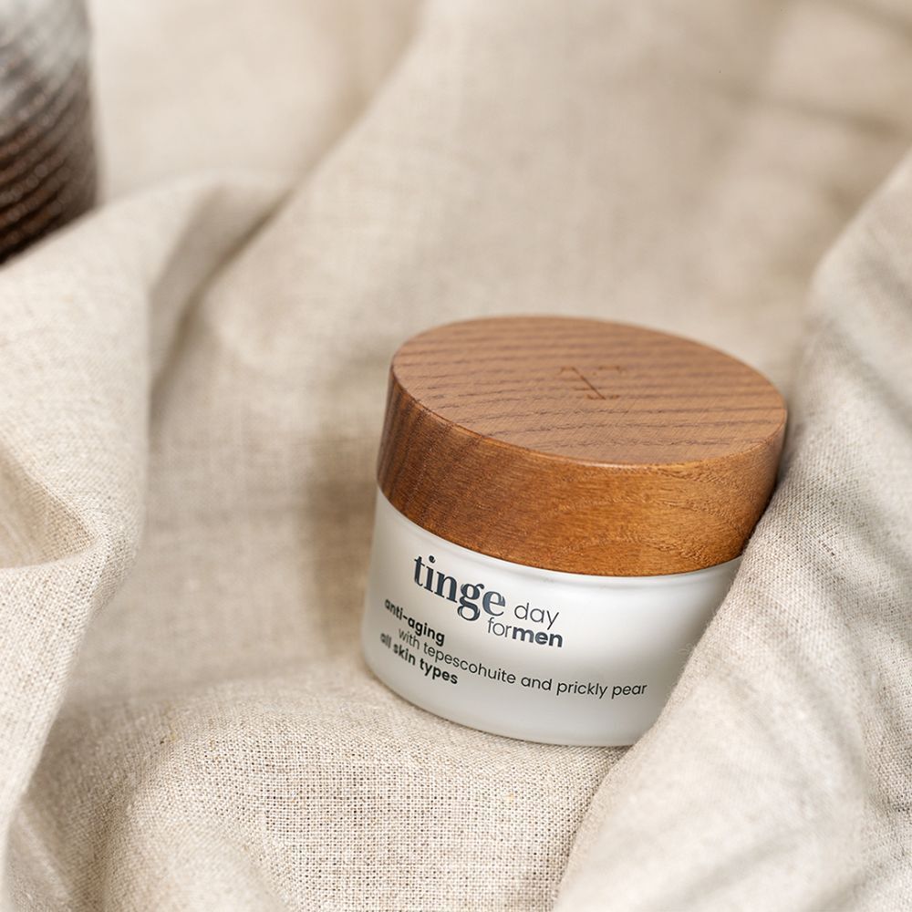 Potje met houten deksel op stof. Opschrift: Tinge day for men, anti-aging, met tepescohuite en cactusvijg, alle huidtypes.