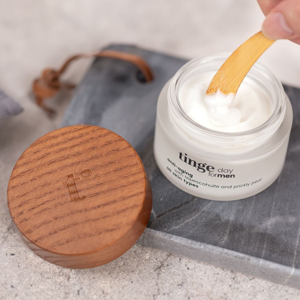 Open potje met houten deksel en lepel. Opschrift: Tinge day for men, anti-aging, met tepescohuite en cactusvijg, alle huidtypes.