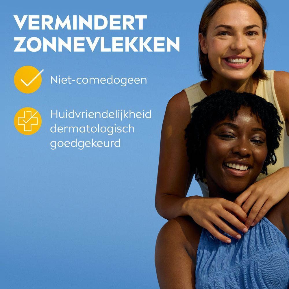 Twee vrouwen lachen. Tekst: Vermindert zonnevlekken. Niet-comedogeen. Huidvriendelijkheid dermatologisch goedgekeurd.