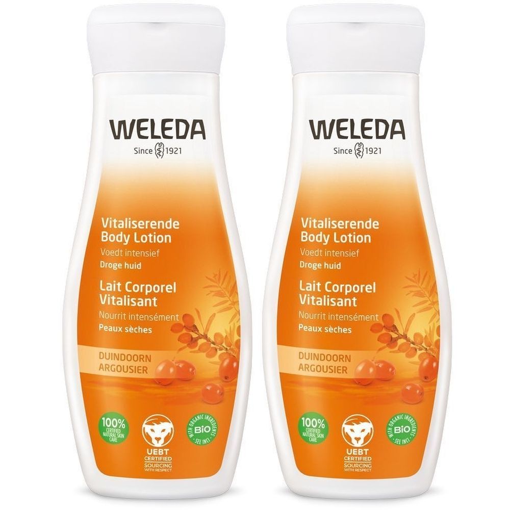 Twee flessen bodylotion. Witte dop, oranje achtergrond. Opschrift: WELEDA, Vitaliserende Body Lotion, Droge huid.