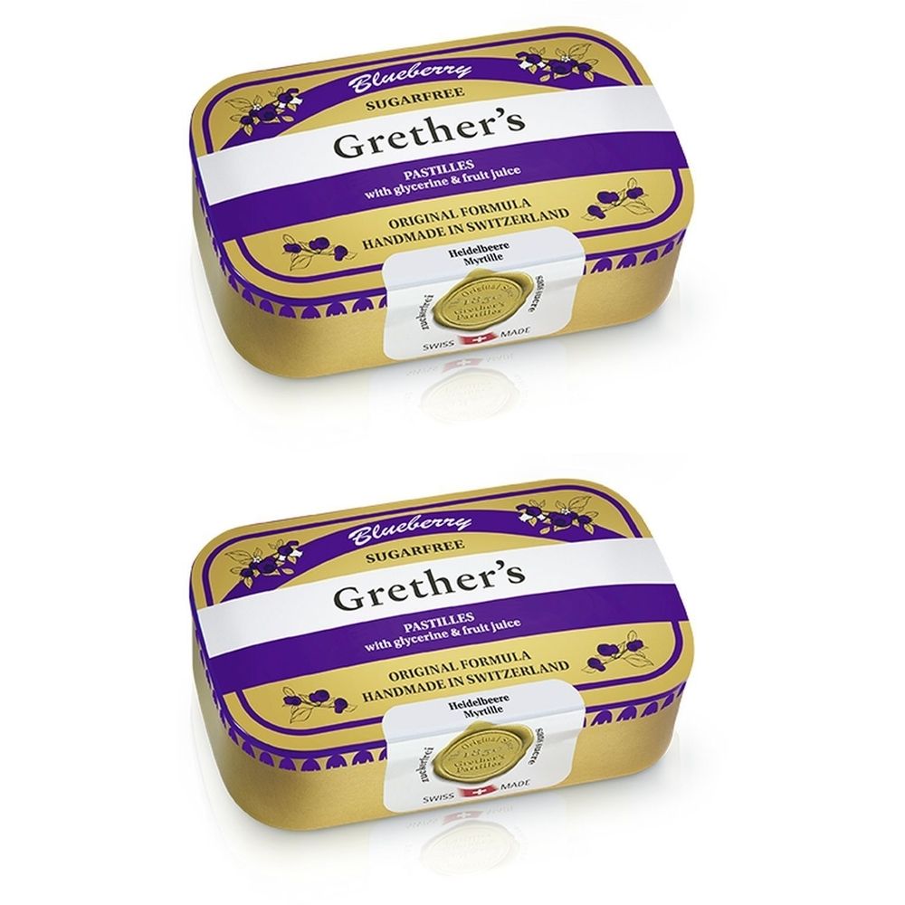 Twee goudkleurige pastilles-dozen met paarse streep en tekst. Opschrift: Grether's Pastilles Blueberry Sugarfree. Gemaakt in Zwitserland.