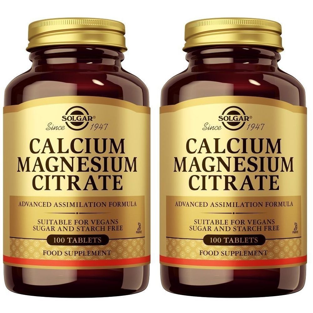 Deux flacons de Solgar Calcium Magnesium Citrate. Bouteilles en verre brun avec des couvercles et des étiquettes dorées. Inscription : Calcium Magnesium Citrate.