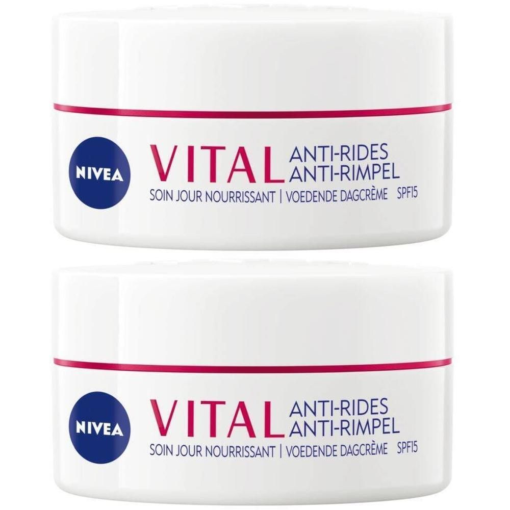 Twee witte potten met rode en blauwe letters. Opschrift: NIVEA VITAL Anti-Rides Soin de Jour Ultra Nourrissant SPF15.