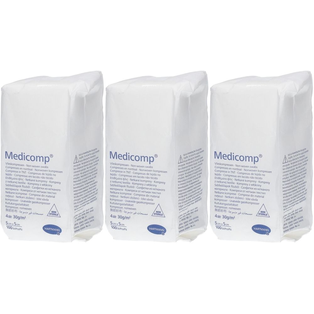 Trois paquets de compresses Medicomp. Emballage blanc avec informations et logo. Pliées en 4.