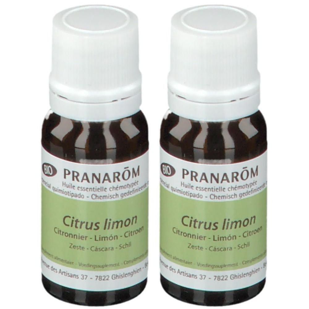 Twee flessen essentiële olie. Bruine glazen flessen met witte dop en groen etiket. Opschrift: Pranarôm, Citrus limon.