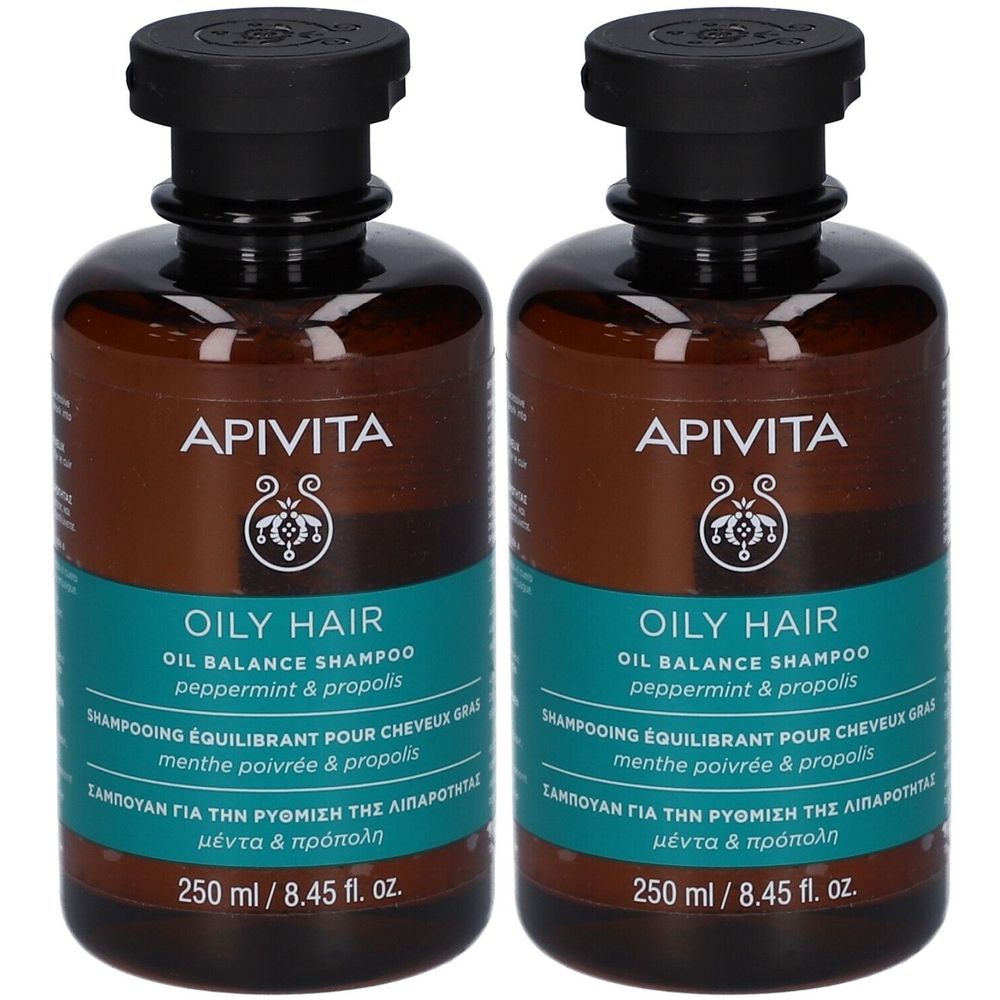 Twee flessen Apivita Oil Balance Shampoo. Bruine flessen met zwarte dop en turquoise etiket. Tekst: Oily Hair, 250 ml.