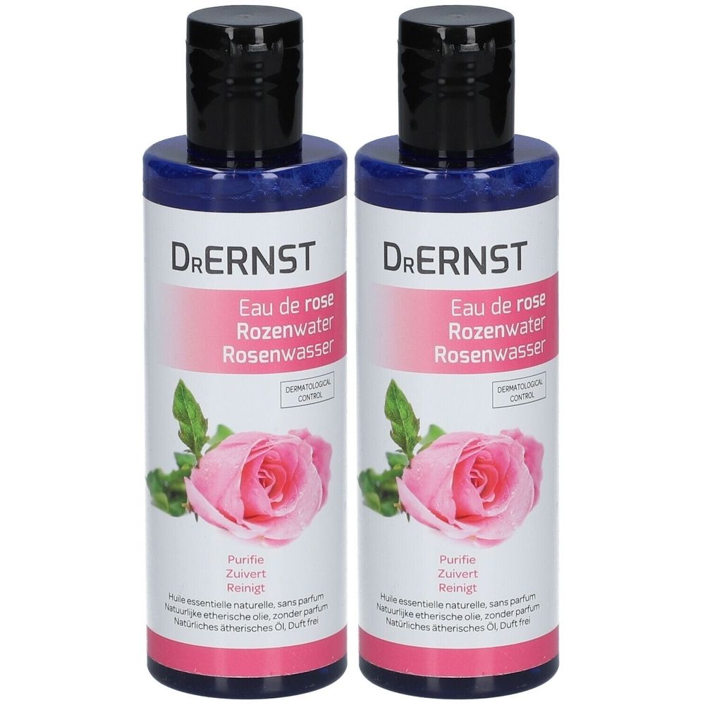 Twee flessen Dr. Ernst Eau de Rose. Witte etiketten met roze band, tekst en roos. Zwarte dop.