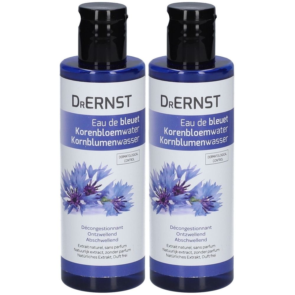 Twee blauwe flessen met zwarte dop. Labels met "Dr. Ernst Eau de bleuet Korenbloemwater Kornblumenwasser".