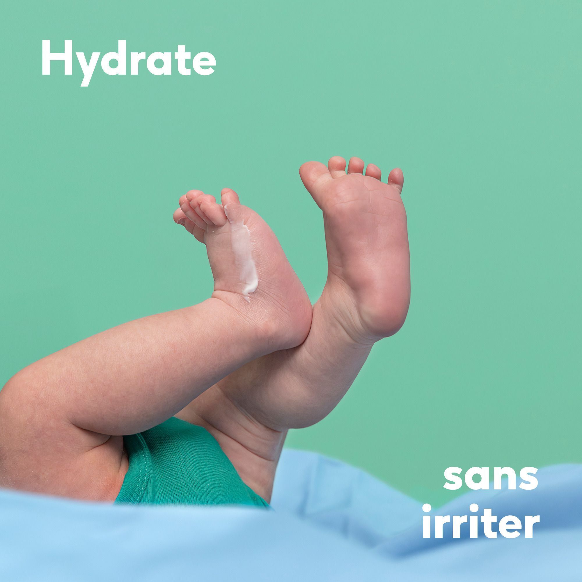 Pieds de bébé avec crème blanche sur le dessus du pied gauche.