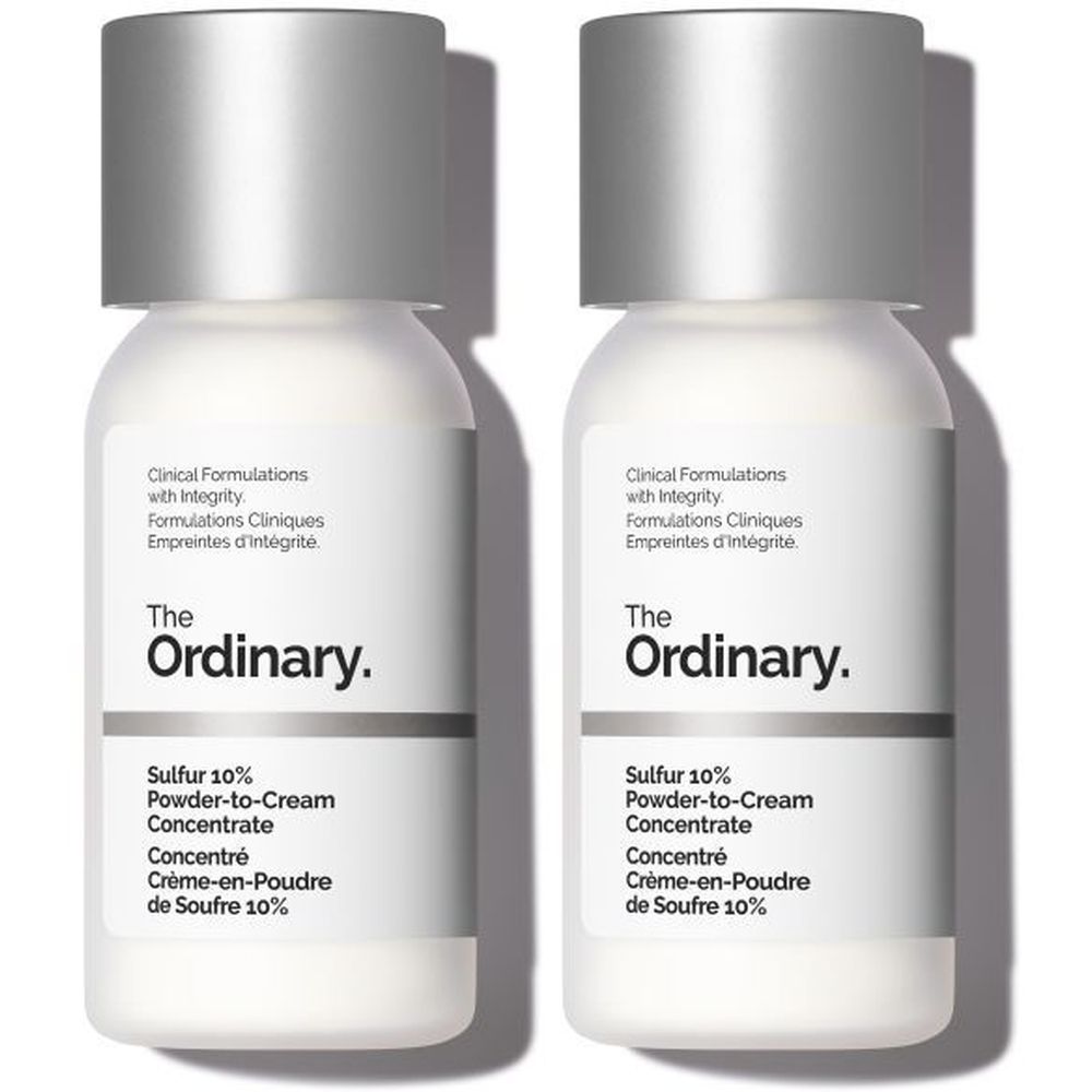 Twee witte flacons met zilveren doppen. Opschrift: The Ordinary, Sulfur 10% Powder-to-Cream Concentrate.