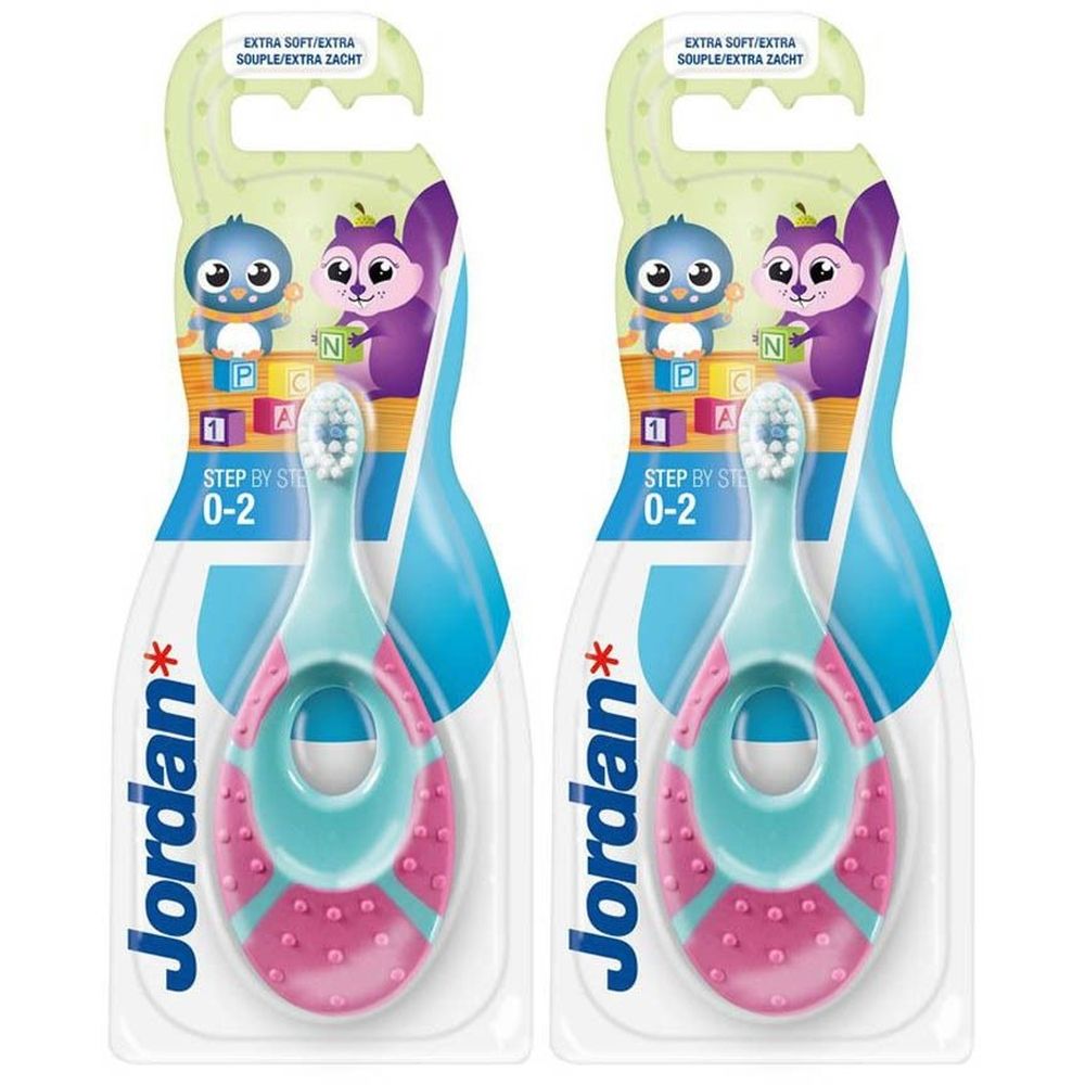 Twee tandenborstels in verpakking. Turquoise en roze handvat, witte borstelkop. Opschrift: Jordan, Step by Step 0-2.