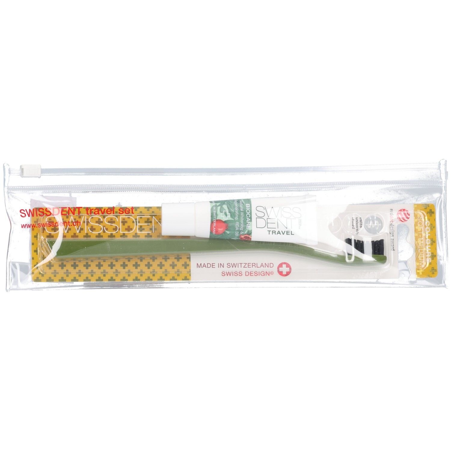 Transparante reisset met tandpasta en groene tandenborstel. Opschrift: SWISSDENT TRAVEL, Swiss Design, Made in Switzerland.