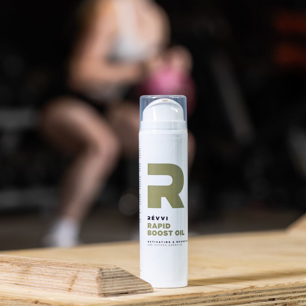 Witte fles met gouden logo en tekst. Productnaam: Rapid Boost Oil. Met transparante dop.