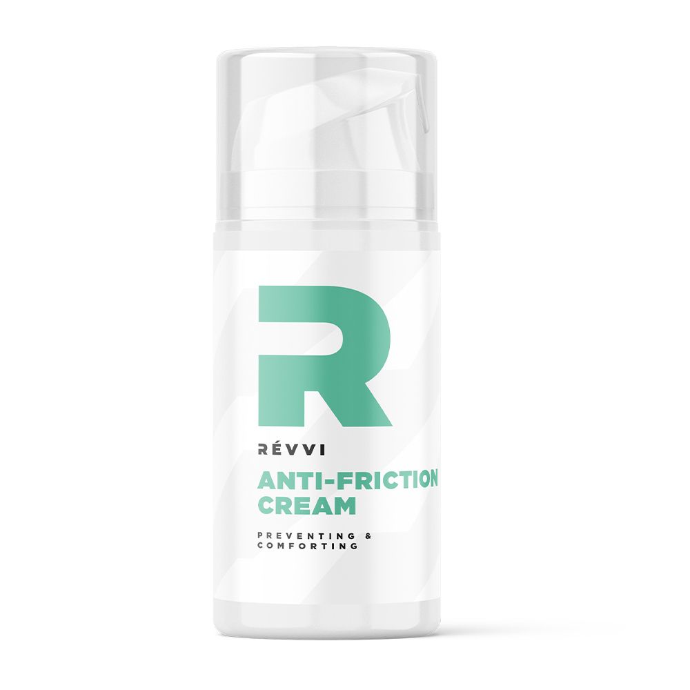 Witte fles met groen "R" logo en tekst. "RÉVVI ANTI-FRICTION CREAM" op de fles. Transparante dop.