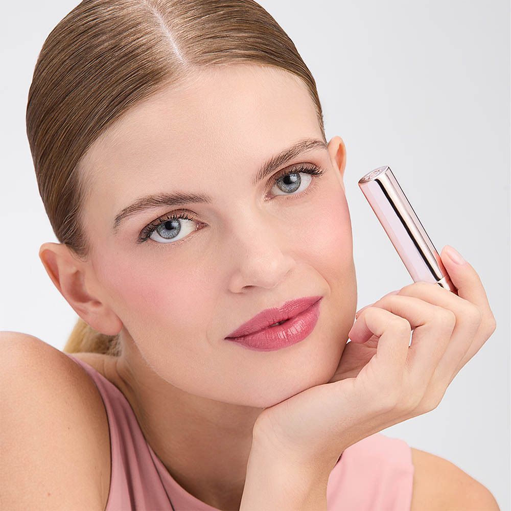 Vrouw met Collistar lipstick. Lipstick aangebracht. Roze top. Witte achtergrond.