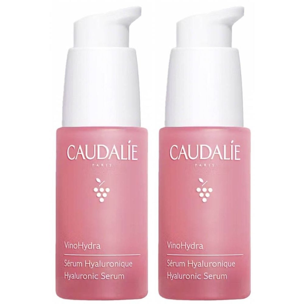 Deux flacons roses avec pompes blanches. Inscription: Caudalie, VinoHydra, Sérum Hyaluronique, Hyaluronic Serum.