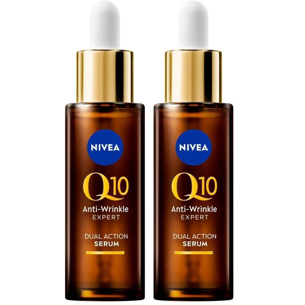 Twee flessen Nivea Q10 Anti-Wrinkle Expert serum. Bruine glazen flessen met gouden doppen en witte pipetten. Blauwe etiketten met witte tekst.