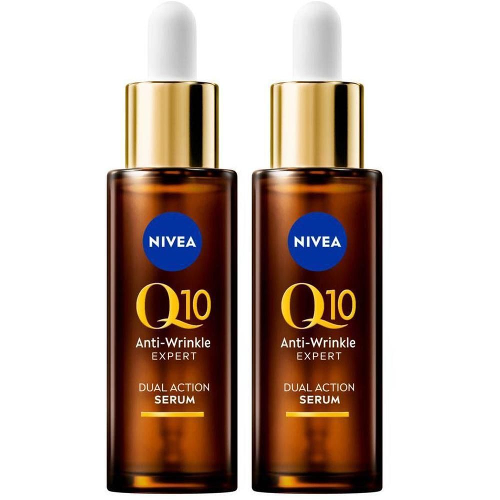 Deux flacons de sérum Nivea Q10 Anti-Rides Expert. Flacons en verre brun avec bouchons dorés et pipettes blanches. Étiquettes bleues avec texte blanc.