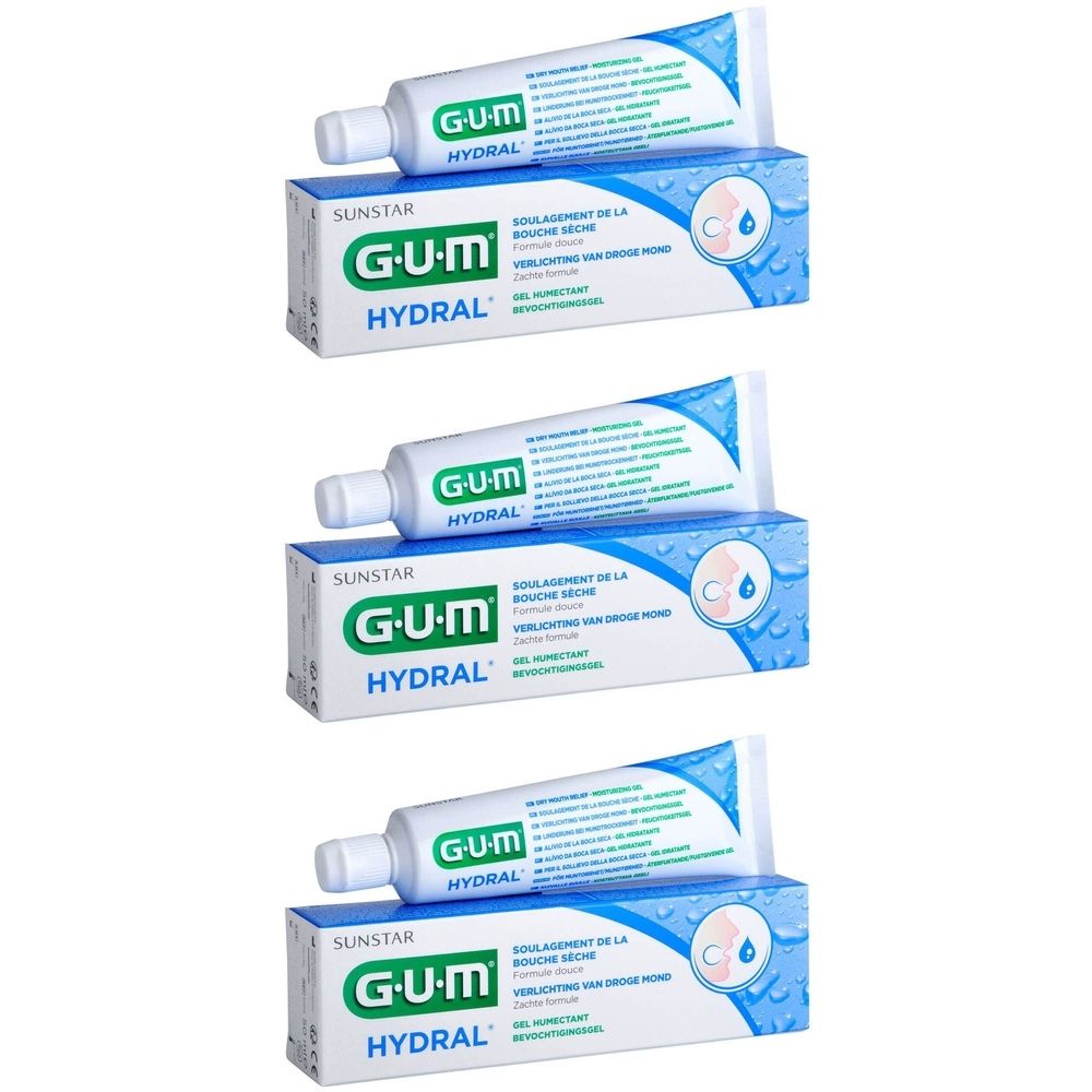 Trois tubes et emballages. "GUM HYDRAL" est écrit sur les tubes et les emballages. Les emballages sont blancs avec des accents bleus.