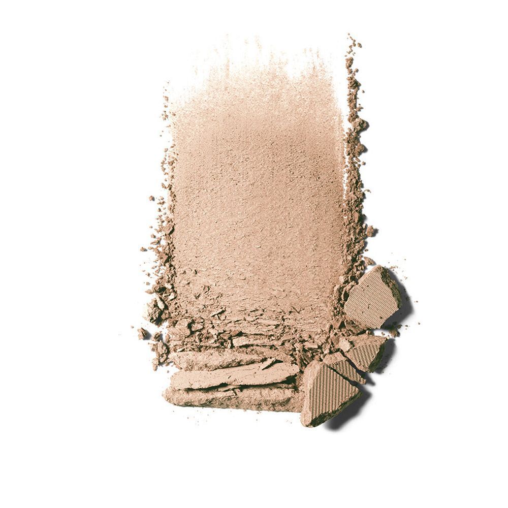 Afveegsel van compactpoeder. Beige poedertextuur met gebroken fragmenten. Op witte achtergrond.