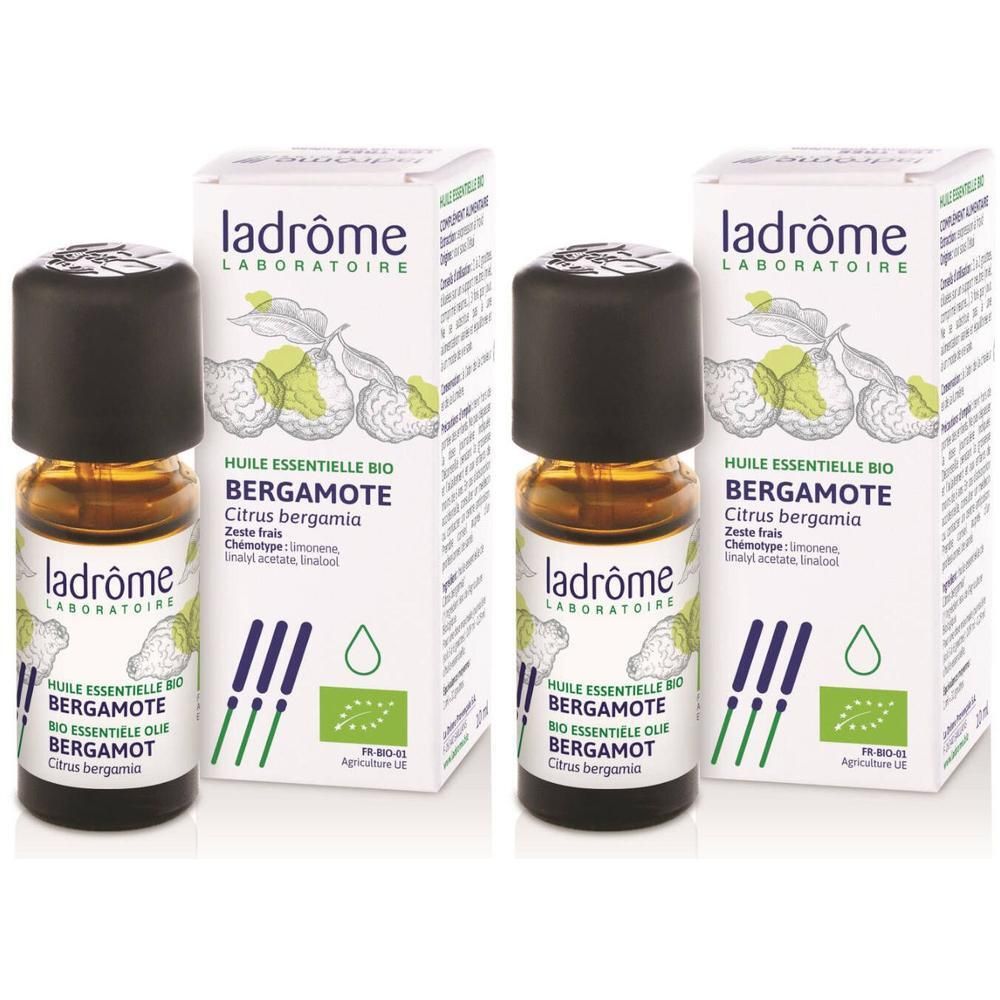 Twee flesjes met zwarte dop en etiket, naast twee dozen met productinformatie en biologisch label.