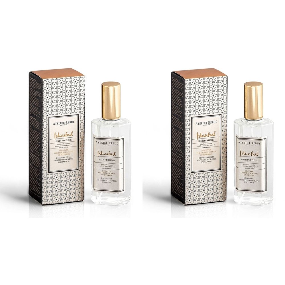 Twee flacons met gouden doppen en rechthoekige dozen. De merknaam en productnaam zijn zichtbaar op de dozen en flacons.