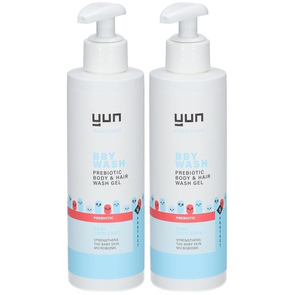 Twee witte flessen YUN BBY wasgel met pomp. Opschrift: BBY WASH, Prebiotic Body & Hair Wash Gel. Blauwe en rode elementen.