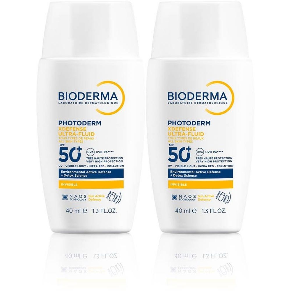 Twee witte flacons Bioderma Photoderm XDEFENSE Ultra-Fluid SPF50+. Gele logo's en tekst. 40 ml.