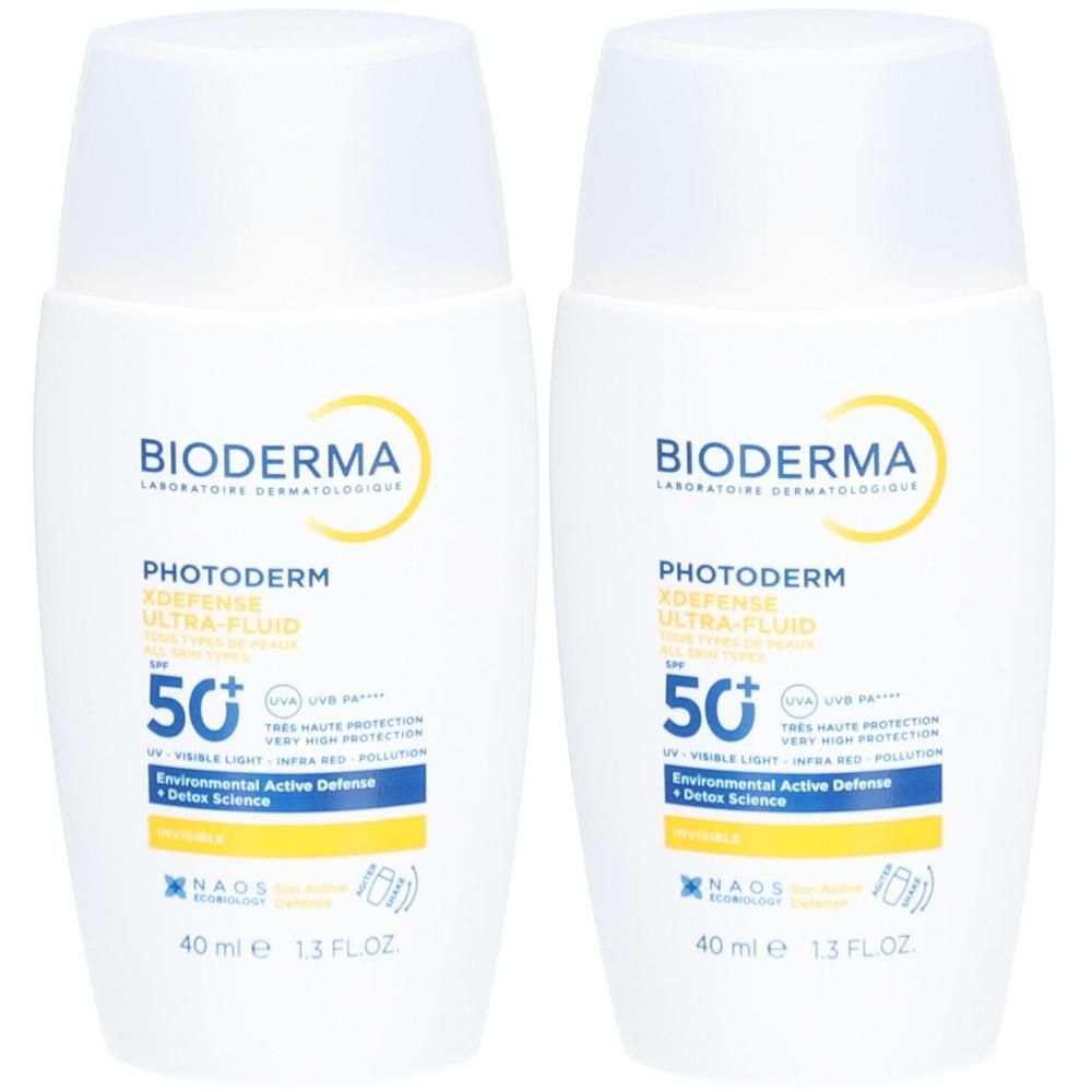 Twee witte flacons met blauwe en gele opdruk. Opschrift: Bioderma Photoderm X-Defense Ultra-Fluid SPF 50+.