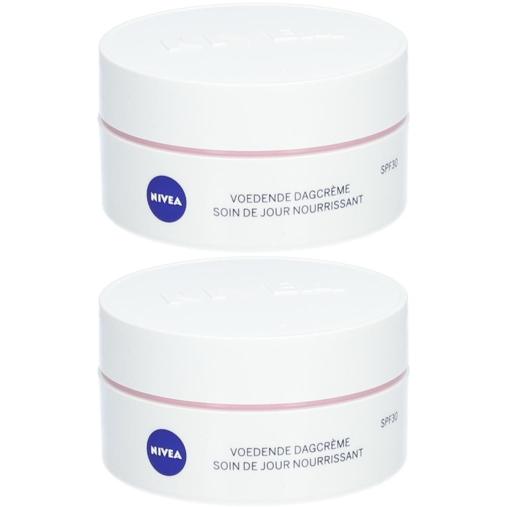 Twee witte potten met roze band en blauwe tekst. Tekst: Voedende Dagcrème, Soin de jour Nourissant, Nivea.