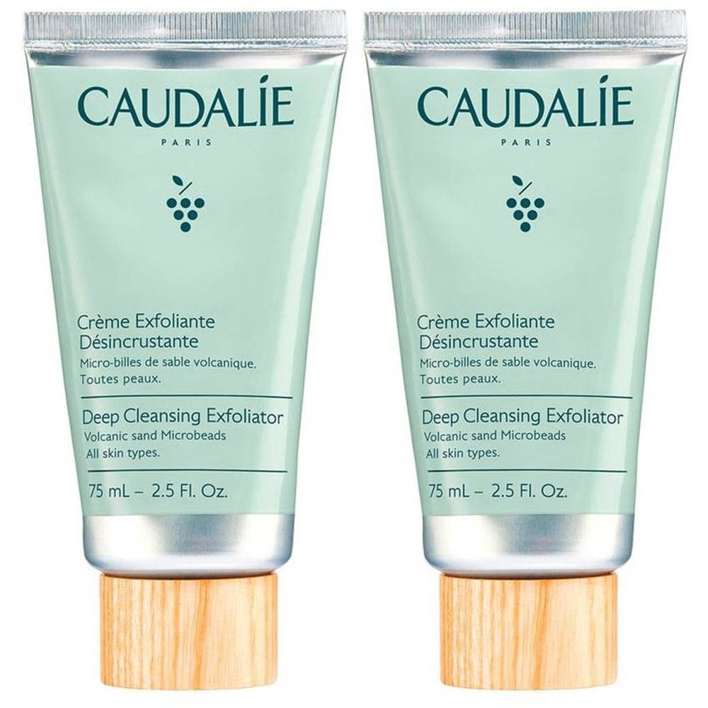 Deux tubes de Caudalie Crème Exfoliante Désincrustante. Tubes vert clair avec bouchons argentés et bases en bois. Texte: Crème Exfoliante.