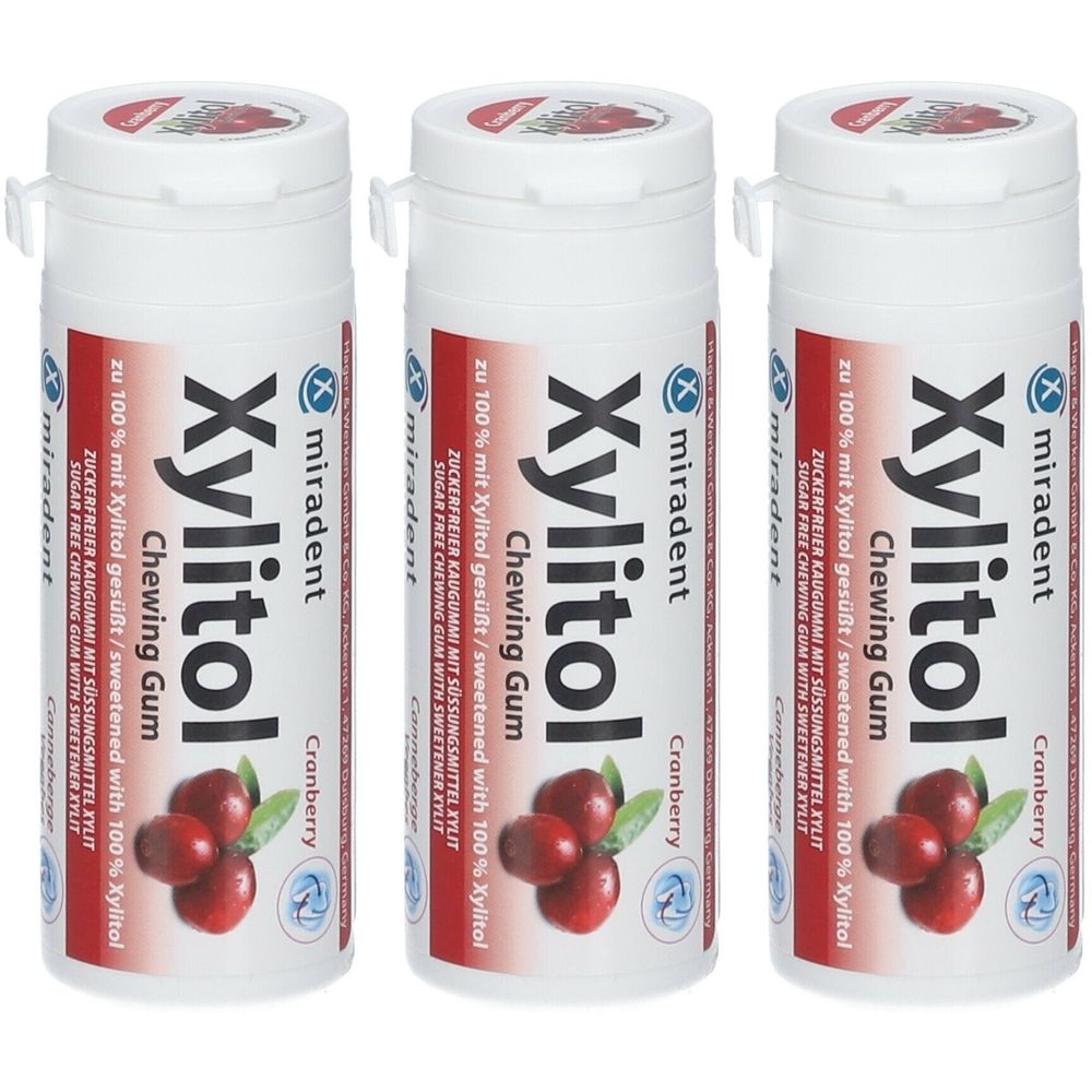 Drie witte flessen Xylitol kauwgom. Opschrift: Xylitol, Cranberry, miradent. Illustratie van veenbessen.