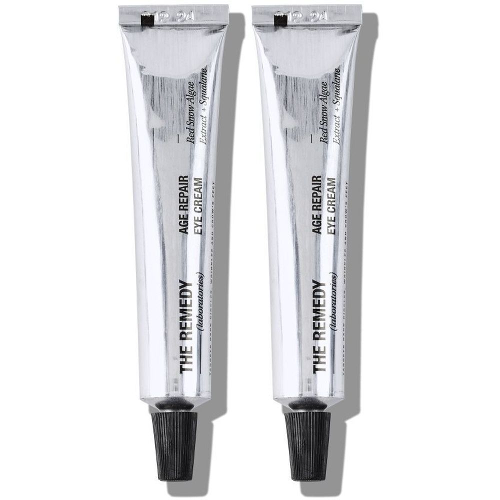 Twee zilverkleurige tubes oogcrème. Opschrift: AGE REPAIR EYE CREAM, THE REMEDY (laboratories).