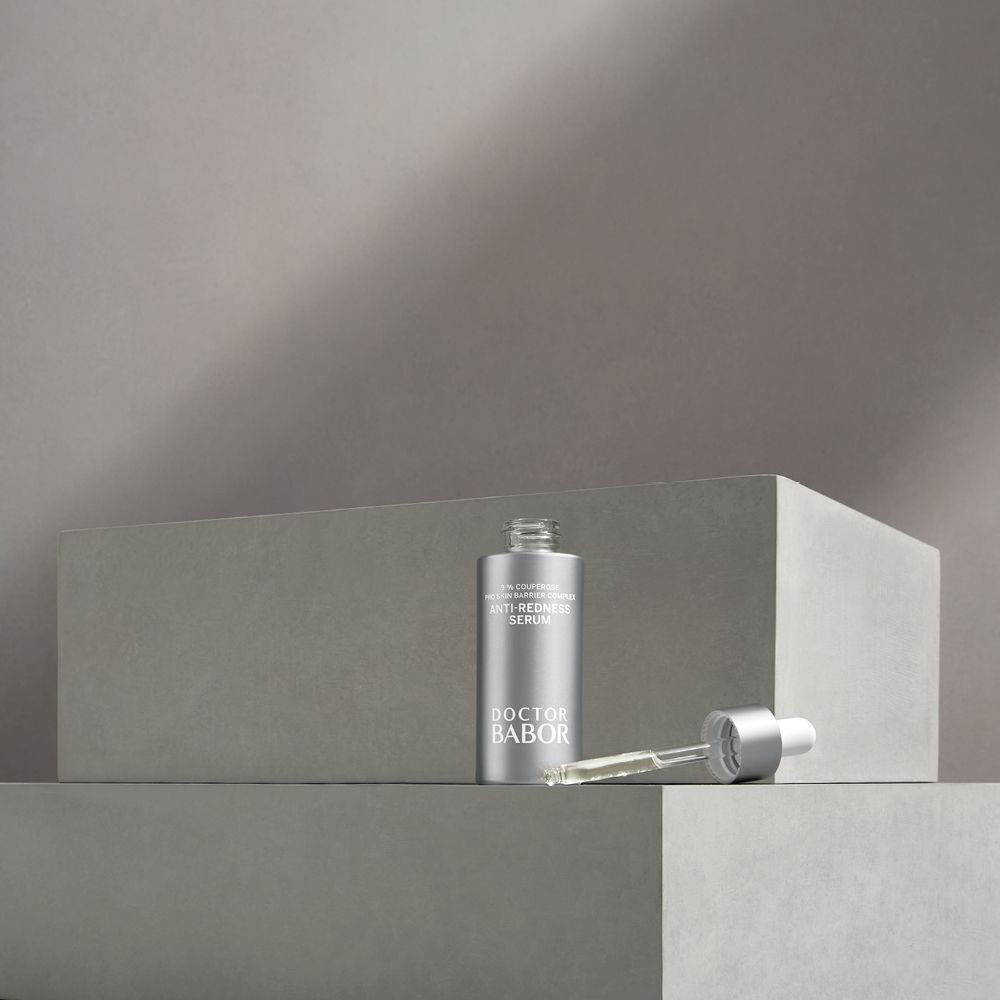 Flacon argenté avec pipette à côté. Inscription: Anti-Redness Serum, Doctor BABOR.