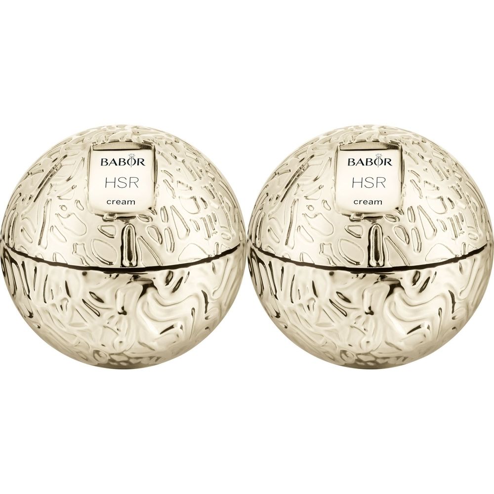 Deux pots de crème dorés en forme de sphère. Sur le dessus, on lit "BABOR HSR cream". Les pots présentent un motif en relief.